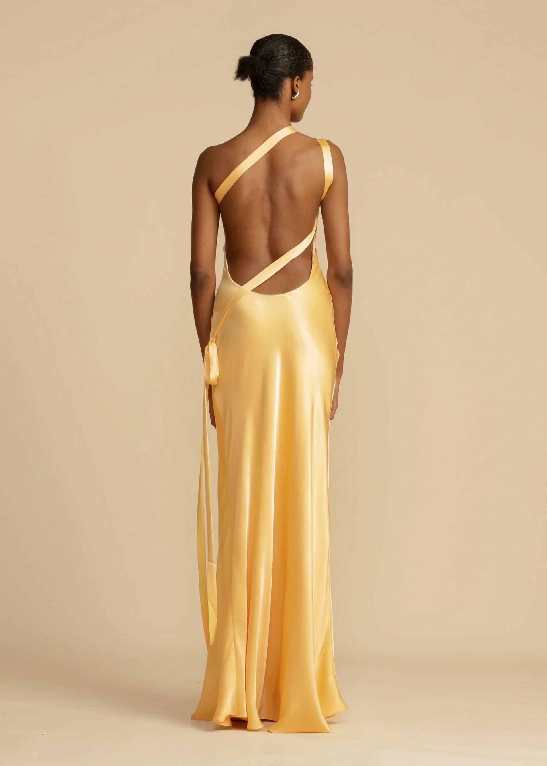 Vestido Longo Aurelia em satin jacquard amarelo com decote assimétrico e costas abertas, ideal para eventos sofisticados. Majestique.4