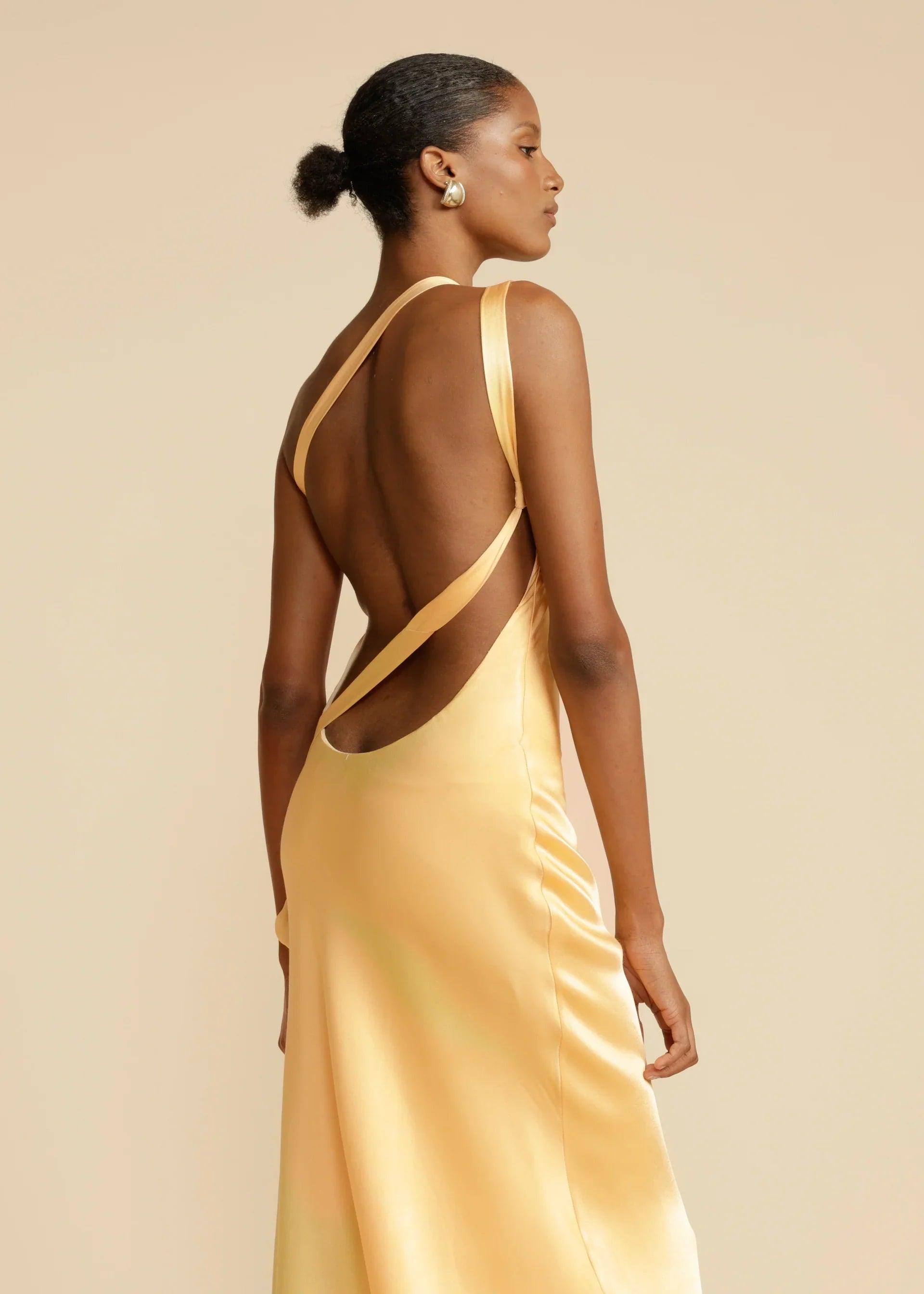 Vestido Longo Aurelia em satin jacquard amarelo com decote assimétrico e costas abertas, ideal para eventos sofisticados. Majestique.5